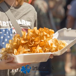 Art in the Park 2021 fresh potato ships held by person in art in the park shirt