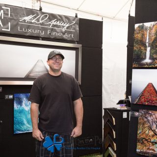 Art in the Park 2021 Mihael Ashley Luxury Fine Art artist standing with his work