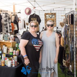 Art in the Park 2021 women in booth with can candles and t shirts