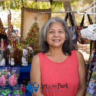 Art in the Park 2021 woman with decorated glasses, bottles and aprons